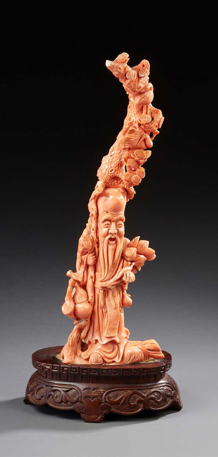 CHINE 重要的橙色珊瑚枝雕刻代表
Shoulao，怀里抱着一个孩子和一枝长寿桃；他靠着一个有栖凤的伞松
木质底座
现代时期
高：38厘米 - 毛重：1844&hellip;