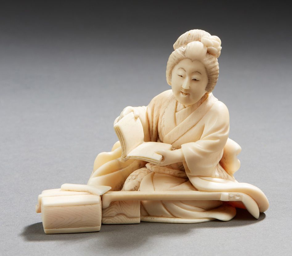 JAPON 象牙雕刻的okimono，描绘了一个坐着的年轻音乐家在她的弦乐器旁打开乐谱
明治时期，1868-1912
高：7厘米
净重：105.8克。