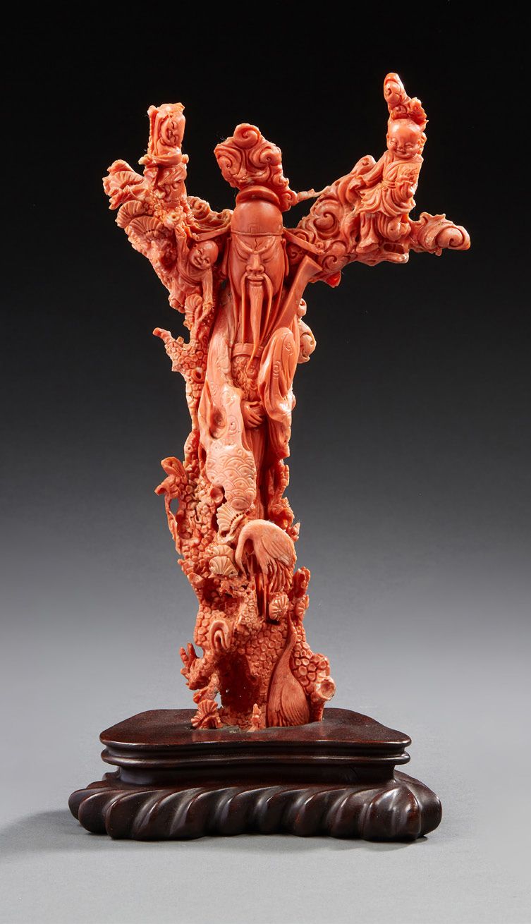 CHINE 雕刻的橙色珊瑚枝表现了一个靠在树上的神仙，周围是儿童和云间的涉水者。
木质底座
现代时期
高：26.5厘米 - 毛重：683.3克。
 （有几块小的&hellip;