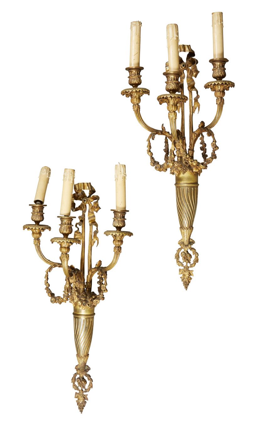 Null 
路易十六风格。
高：65厘米，一对三灯镀金青铜壁炉；轴心为花瓶形式，有通道悬挂在宽大的丝带上，灯臂上装饰有花环。