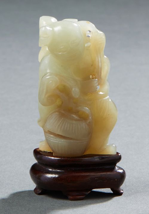 CHINE Light grey jade figurine of a child kneeling near a half-open basket holdi&hellip;