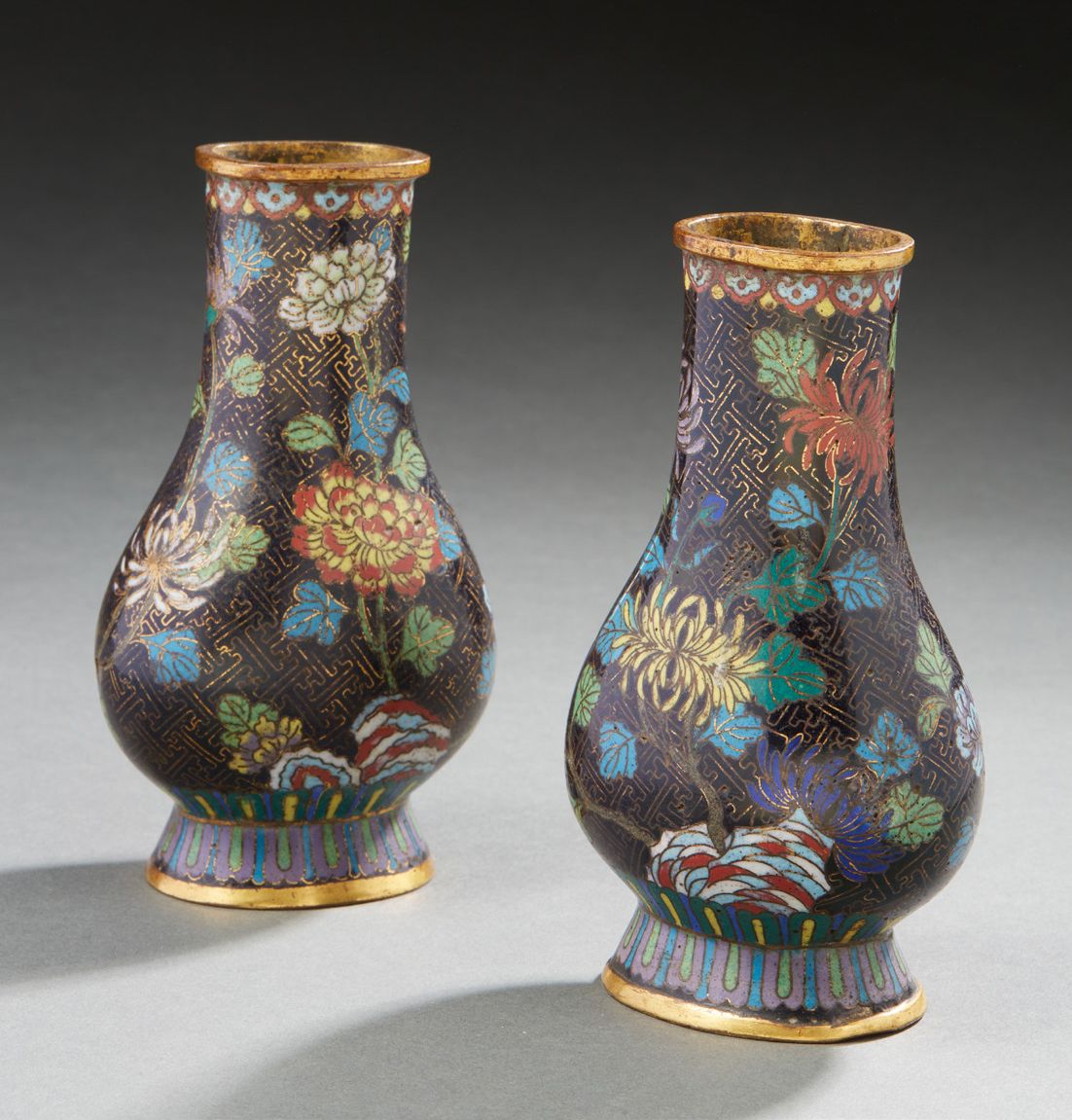 CHINE 一对景泰蓝青铜柱形花瓶，黑底，以多色装饰的水晶花和大红花，有穿孔的岩石，19世纪（其中一个花瓶的一侧有震惊）高：14.5厘米