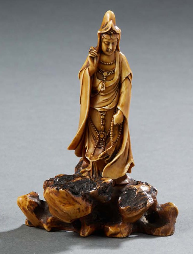 JAPON Carved ivory figurine representing the goddess Kannon standing on a rock. &hellip;