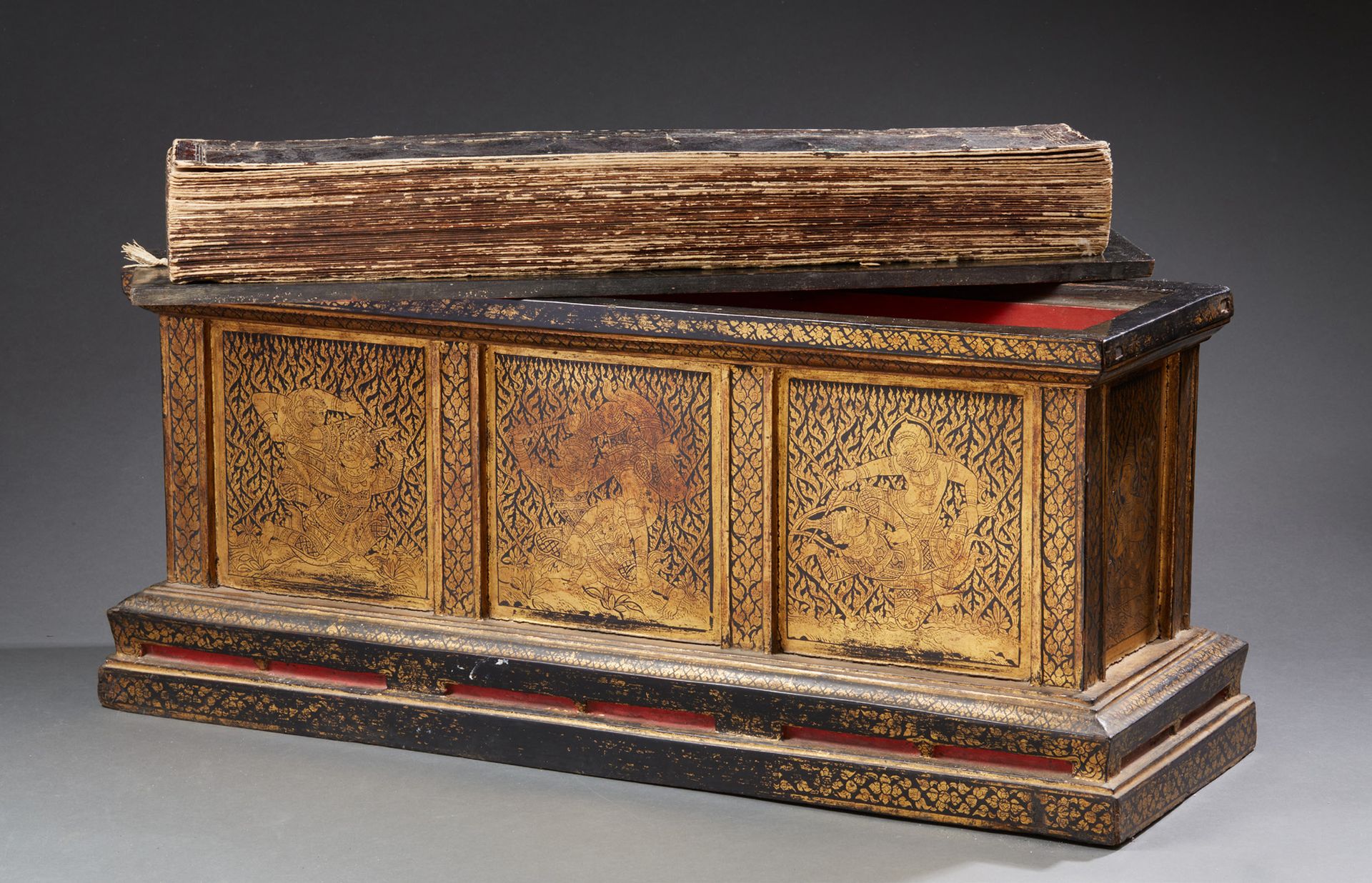 ART SINO-TIBETAIN 雕花木箱，漆面和镀金封面，内有一本祈祷书。饰有佛教万神殿的人物。19世纪。尺寸：34 x 84 x 28厘米（可能缺少一片叶&hellip;