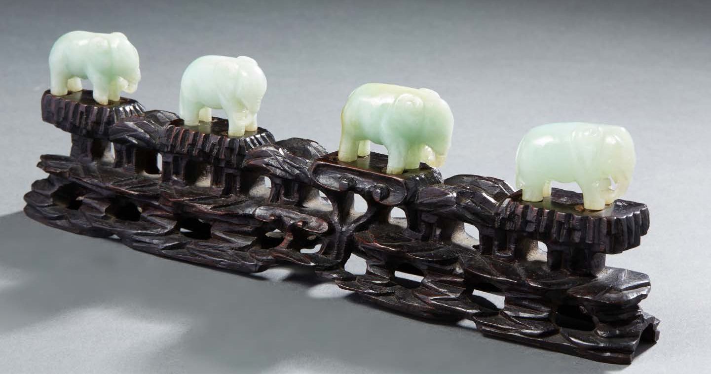 CHINE Four carved light green jade figurines representing elephants. Carved wood&hellip;