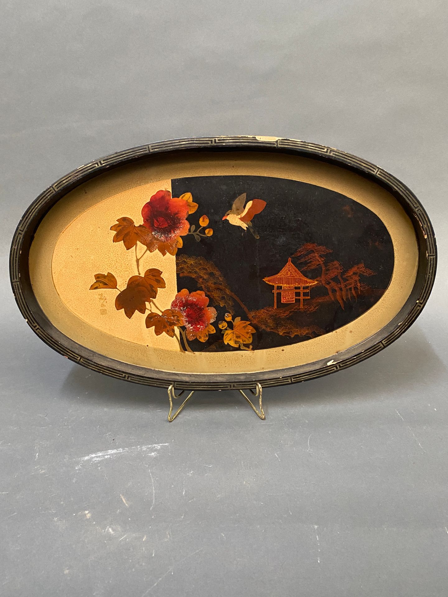 Null 椭圆形的发黑和涂漆的木质托盘，装饰有亚洲景观。

左下方有签名。

1920年左右工作。

尺寸：27,5 x 45,5厘米（摩擦）。