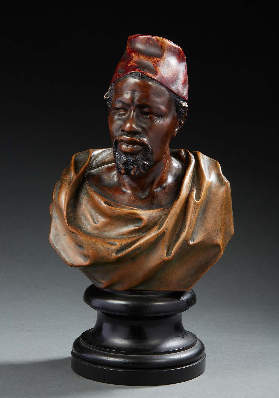 Null 一个圆形的木雕半身像，涂有 "自然 "漆，表现了一个非洲人向右看，戴着他的头发。
大约在1900年。
，它呈现在一个发黑的木头圆形模制基座上。
整体高&hellip;