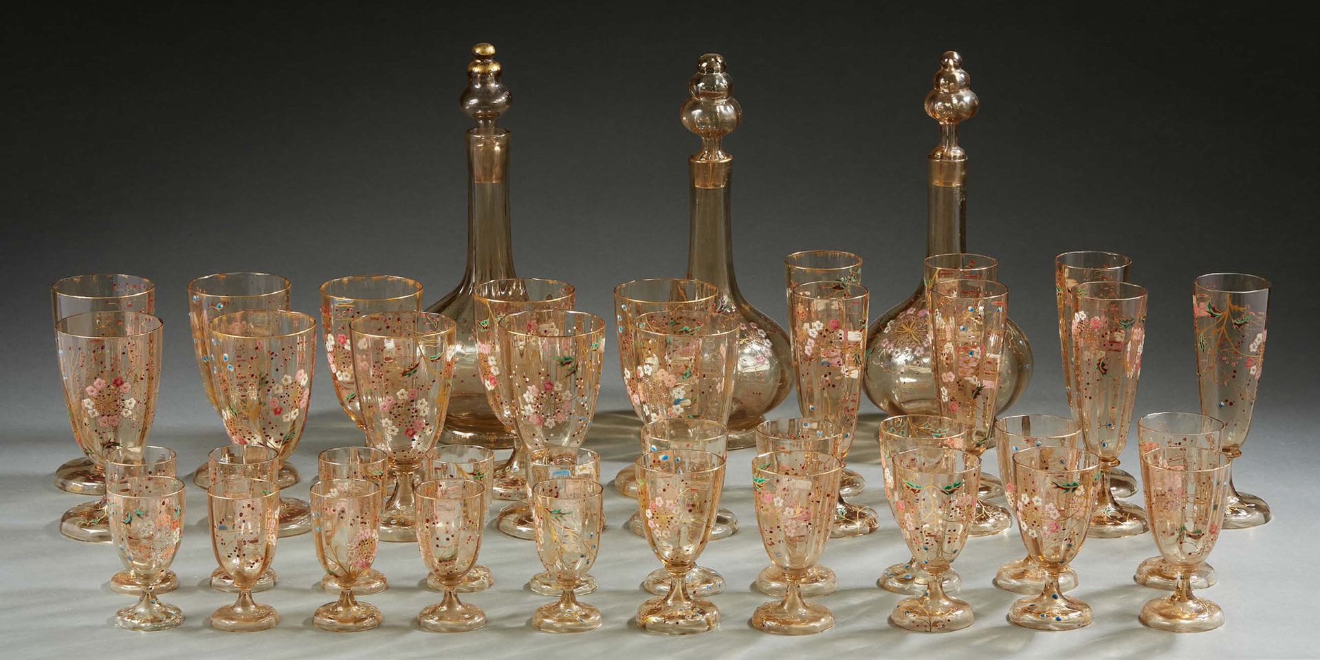 Émile GALLÉ (1846-1904) 餐具包括三个带瓶塞的醒酒器，十个水杯，十个酒杯，十个利口酒杯，七个香槟酒杯和三个杯垫。棕色玻璃样板用多色珐琅和镀&hellip;