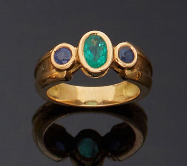 Null 750毫米的黄金戒指，在两颗圆形蓝宝石之间镶嵌了一颗椭圆形的祖母绿，整个戒指以封闭的方式镶嵌在有边框的主体上。
TDD : 52
黄金的净重：8.4克&hellip;