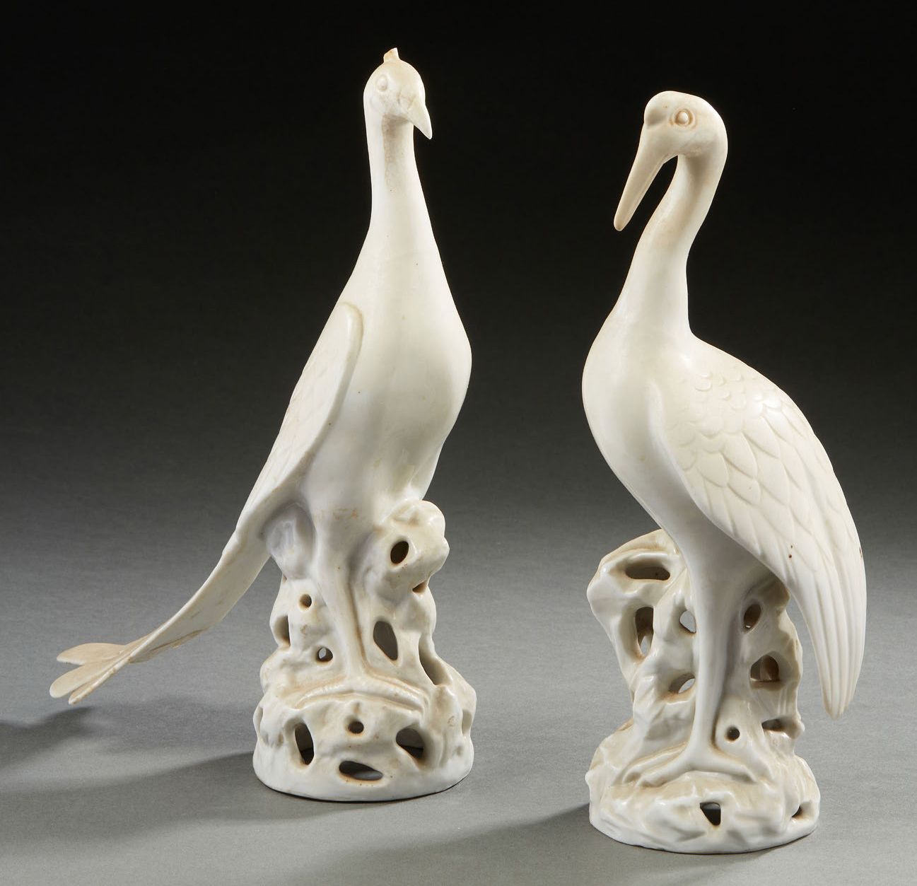 CHINE, XXe siècle 两只白瓷鸟代表孔雀和鹤，栖息在岩石上。(事故和对孔雀的修复）。
H.31厘米