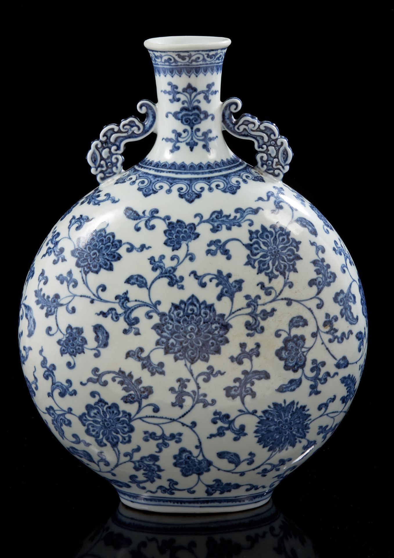 CHINE, XXe siècle 青花瓷葫芦形花瓶，扁圆形瓶身，饰以花卉和菊花卷。颈部装饰有两个风格化的把手。
H.34,5 CM