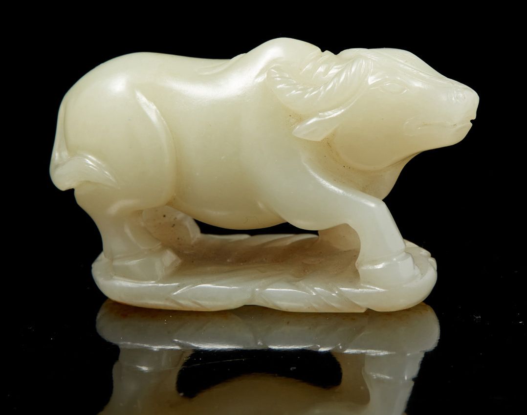 CHINE, fin de l'époque QING 卵石上雕有锈纹的青瓷玉器主题，代表一头水牛躺在底座上。
尺寸：7,3 x 3,8 cm