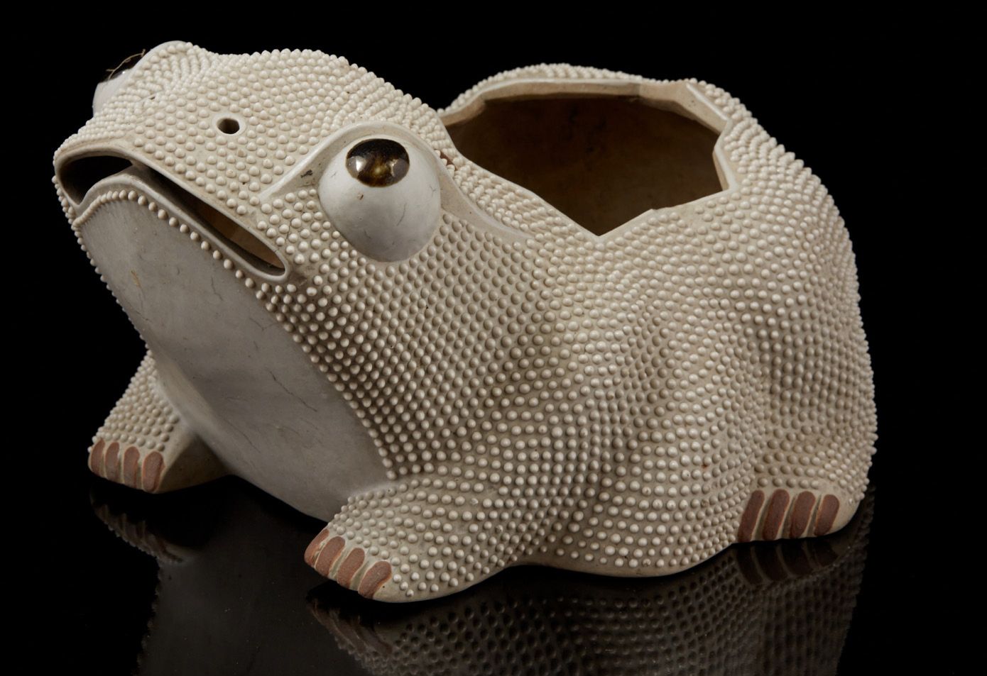 CHINE, XIXe siècle 一个米色的珐琅彩饼干花盆，形状是一只蟾蜍，眼睛睁得大大的，嘴巴张开。
轻微损坏和烧制缺陷。
尺寸：15 x 26厘米。