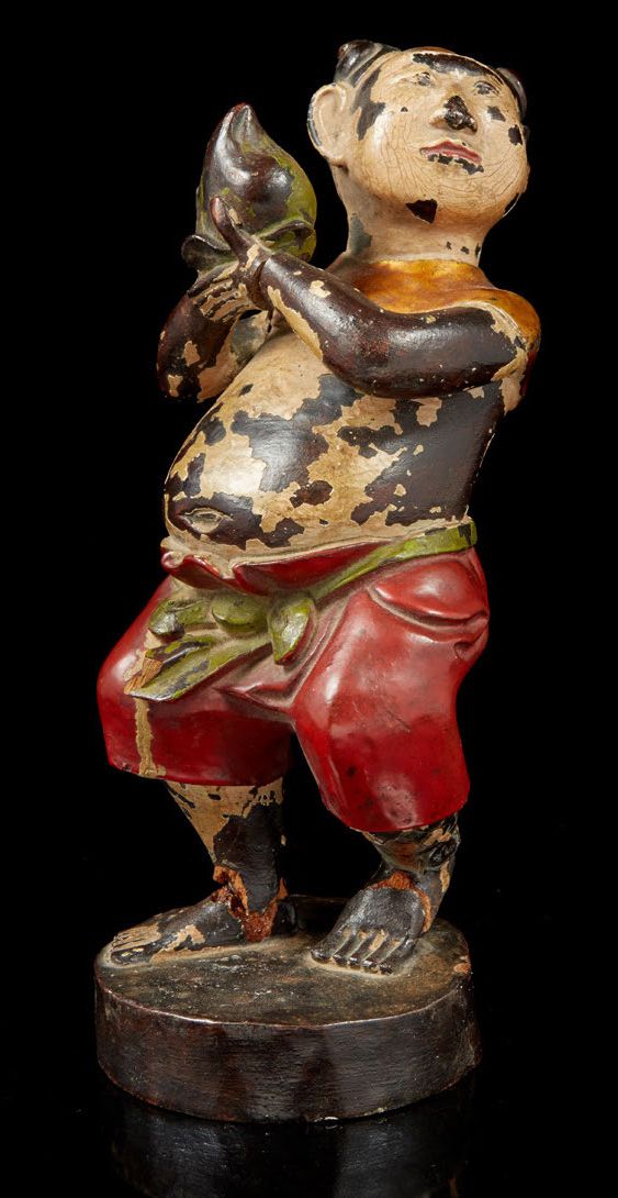 VIETNAM, fin XIXe siècle 漆面和雕刻的木质主题，代表一个手持长寿桃的孩子。
漆面跳跃。
H.21厘米