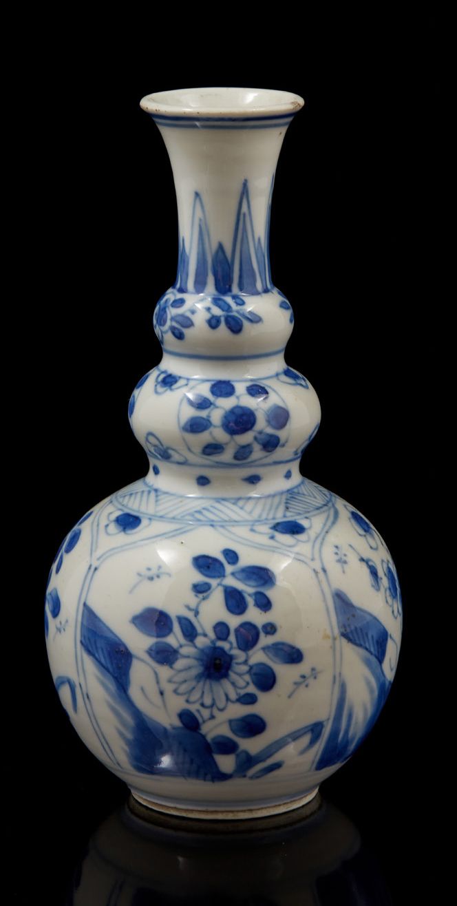 CHINE, période KANGXI (1662-1772) 青白瓷小花瓶，球形瓶身，颈部有双凸起，装饰有莲瓣状的花纹图案（颈部有小缺口）。
H.15厘米