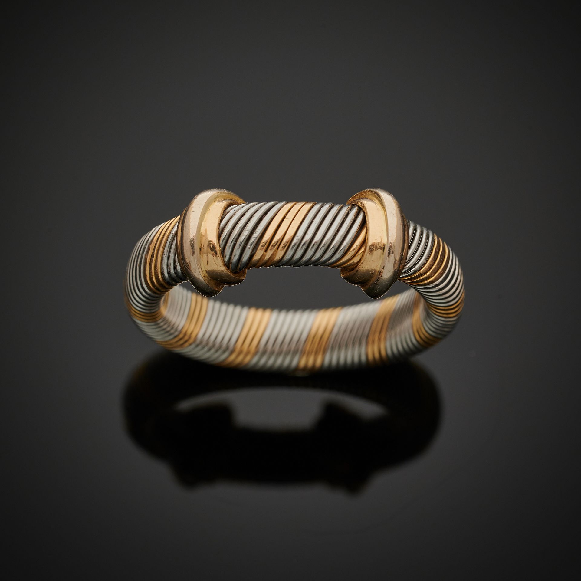 Null 卡地亚，巴黎。
750毫米金和双色钢戒指，由一个斜卷轴组成，由两个双色金镶边环固定。
签名为卡地亚，编号为94318
TDD: 53
净重：5.7克