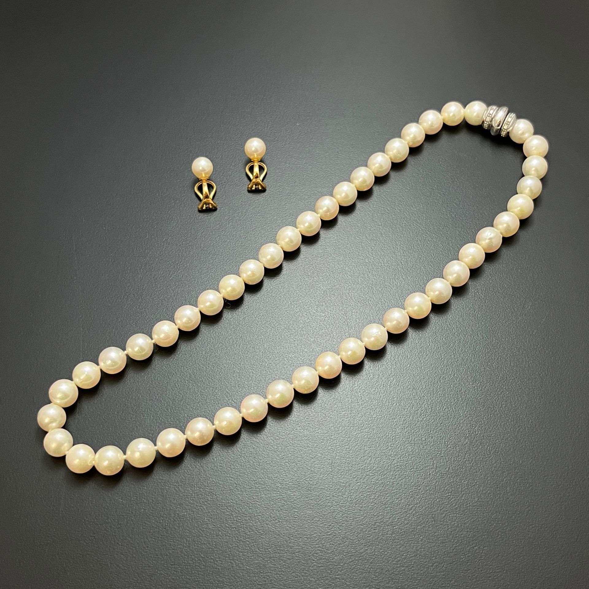 Null 750毫米的黄金套装包括: 
- 一条总重49克的养殖珍珠项链，白金Godron扣和小型明亮式切割钻石。 
- 一对总重4.2克的养殖珍珠耳夹。装在一&hellip;