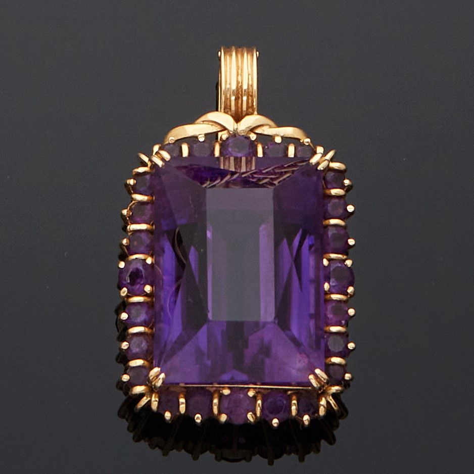 Null 585毫米的黄金吊坠，在一圈圆形紫水晶中镶嵌了一颗重约45克拉的祖母绿切割紫水晶。 
毛重：17克。
