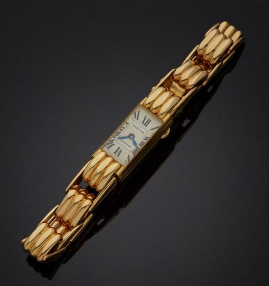 Null 卡地亚。 83577。约在1950年。 
750毫米黄金女士腕表，白色表盘（磨损），黑色罗马数字，轨道标记，蓝钢矛形指针。黄金腕带，带三条纹网，玫瑰金&hellip;