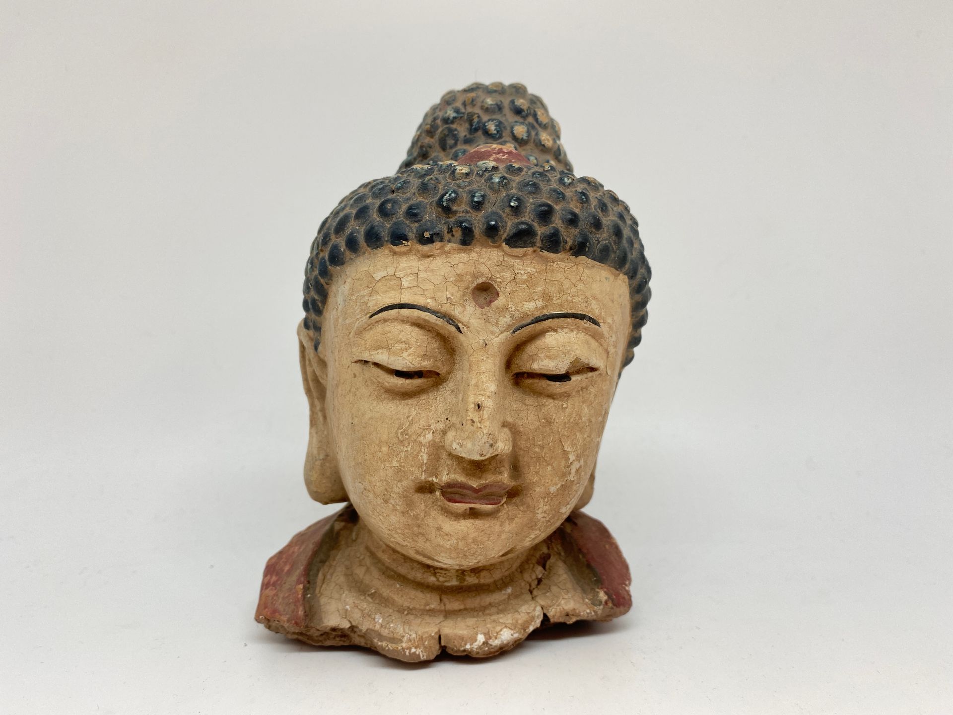 Null CHINA
Buddha head in polychrome sandstone.
H. 15 cm
(missing)