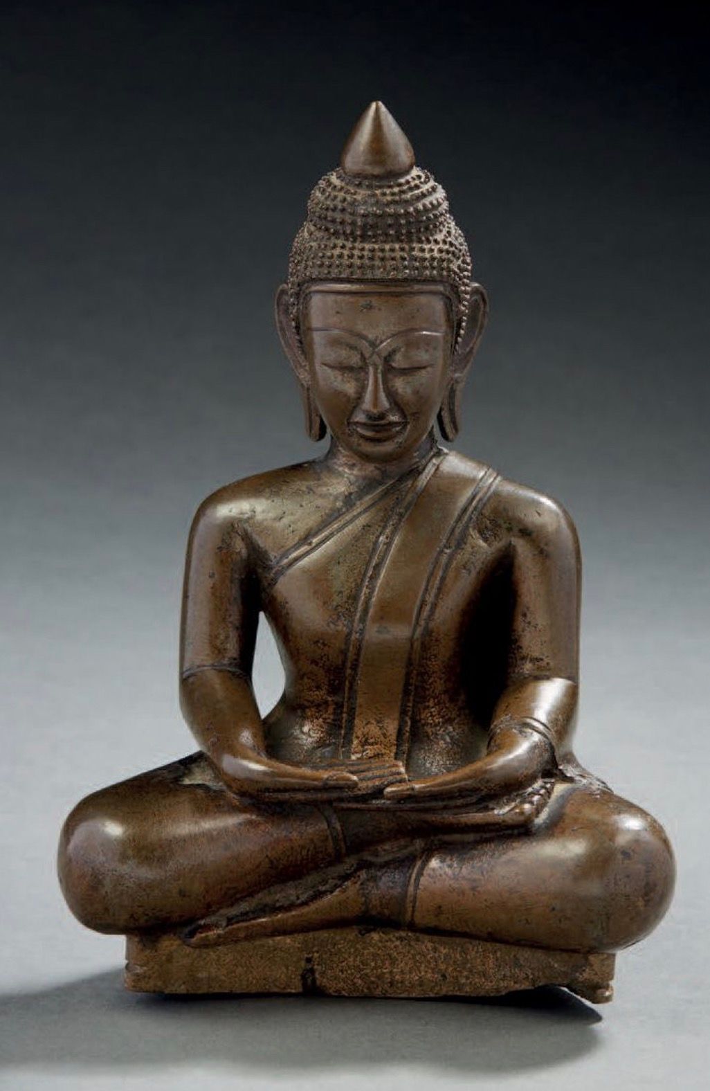 NORD THAÏLANDE, LAOS XXe siècle 带有金属光泽的青铜题材，表现佛祖坐着打坐，双手持禅定法。
H.17.7厘米