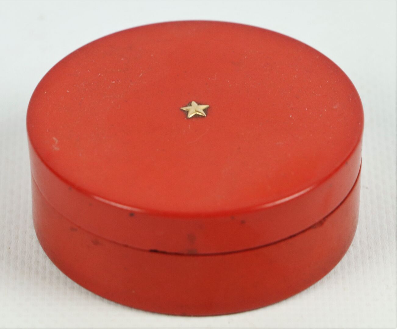 Null 红漆圆盒，内部为棕色玳瑁。

盖子上装饰着一颗星，可能是金色的。

18世纪。

H_2.5 cm D_6.5 cm。
