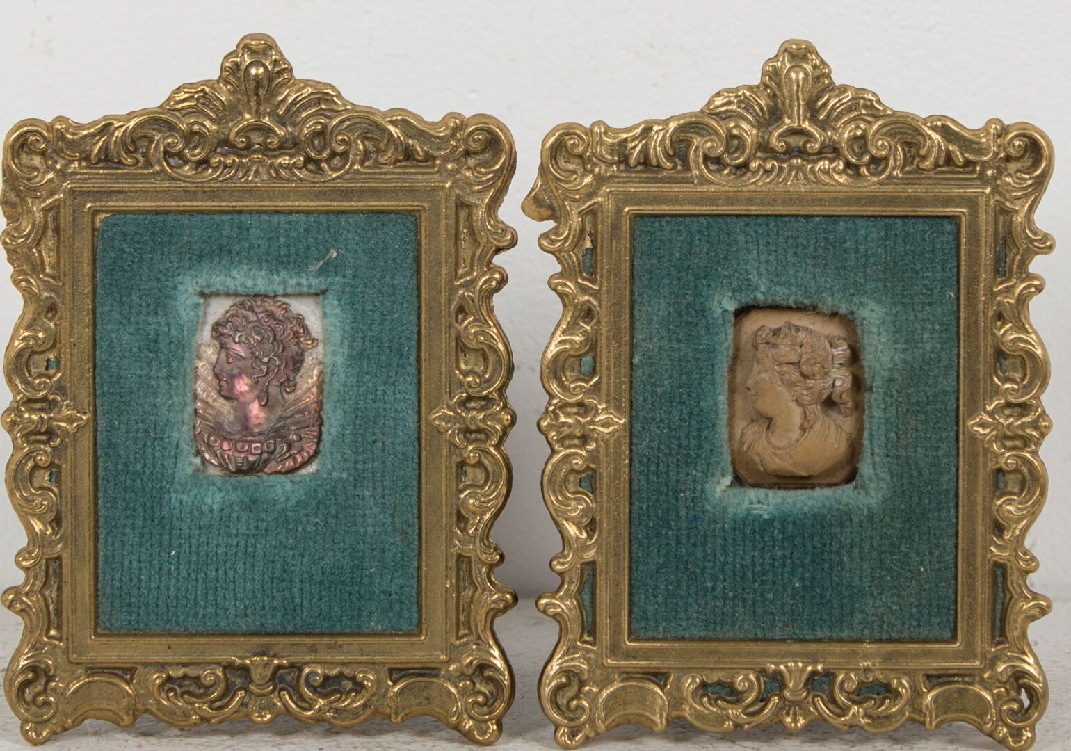 Null 两个描绘古代女性半身像的奖章，一个是珍珠母，另一个是熔岩石。

高_2.7厘米，宽_2厘米，大约。

呈现在天鹅绒背景的框架中