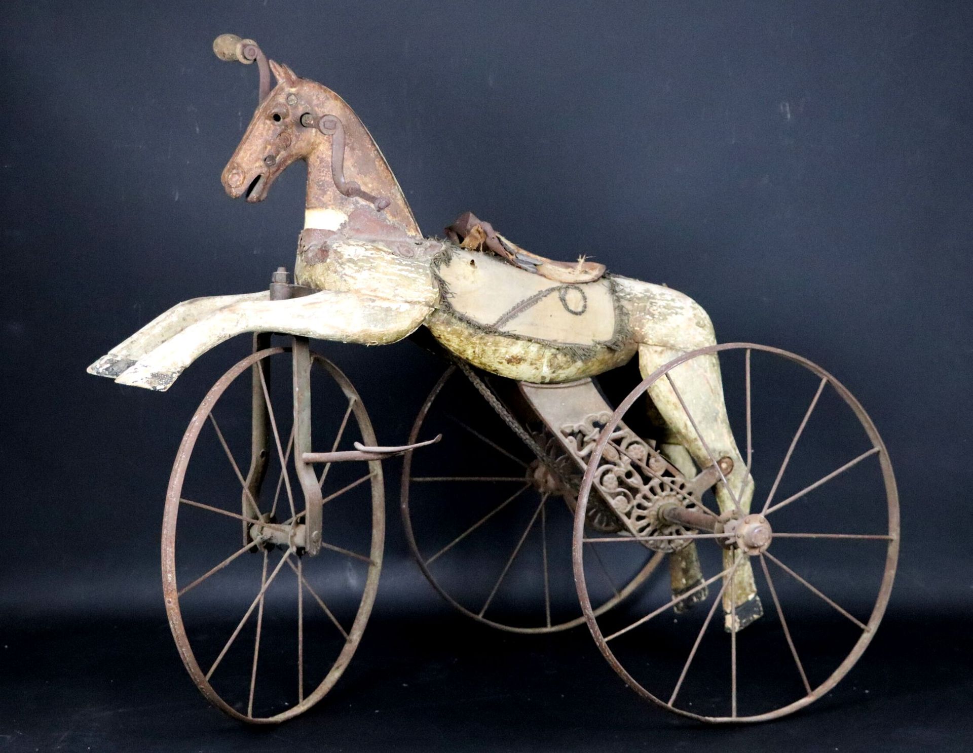Null Dreirad in Form eines Pferdes, aus Holz, Gusseisen und Metallrädern.
Epoche&hellip;