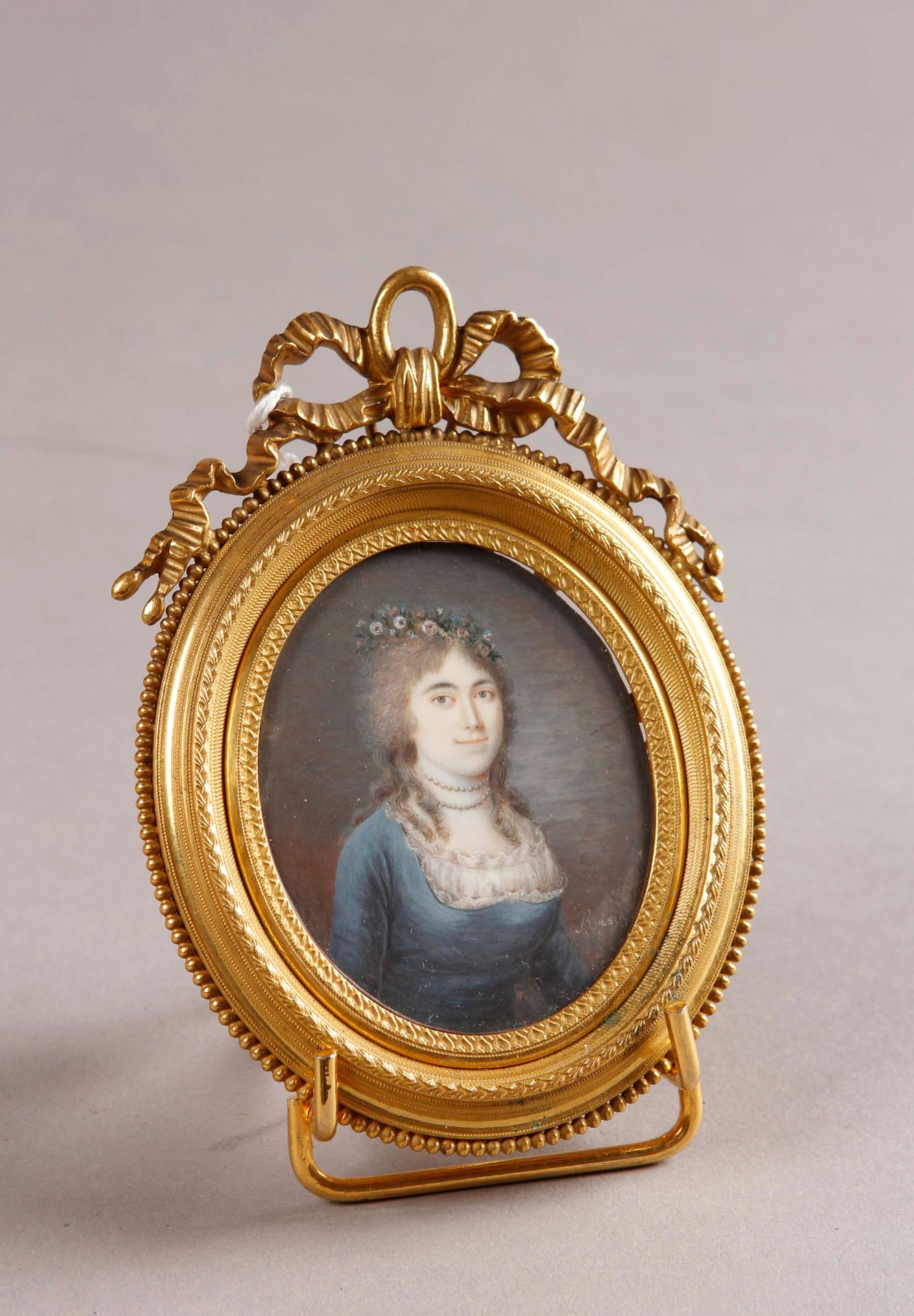 Null ROISIN（活跃于19世纪前四分之一）。

穿着蓝色连衣裙、戴着两串珍珠项链、戴着自然花冠的年轻女子的画像

象牙上的微型画，椭圆形，右下方有签名。&hellip;