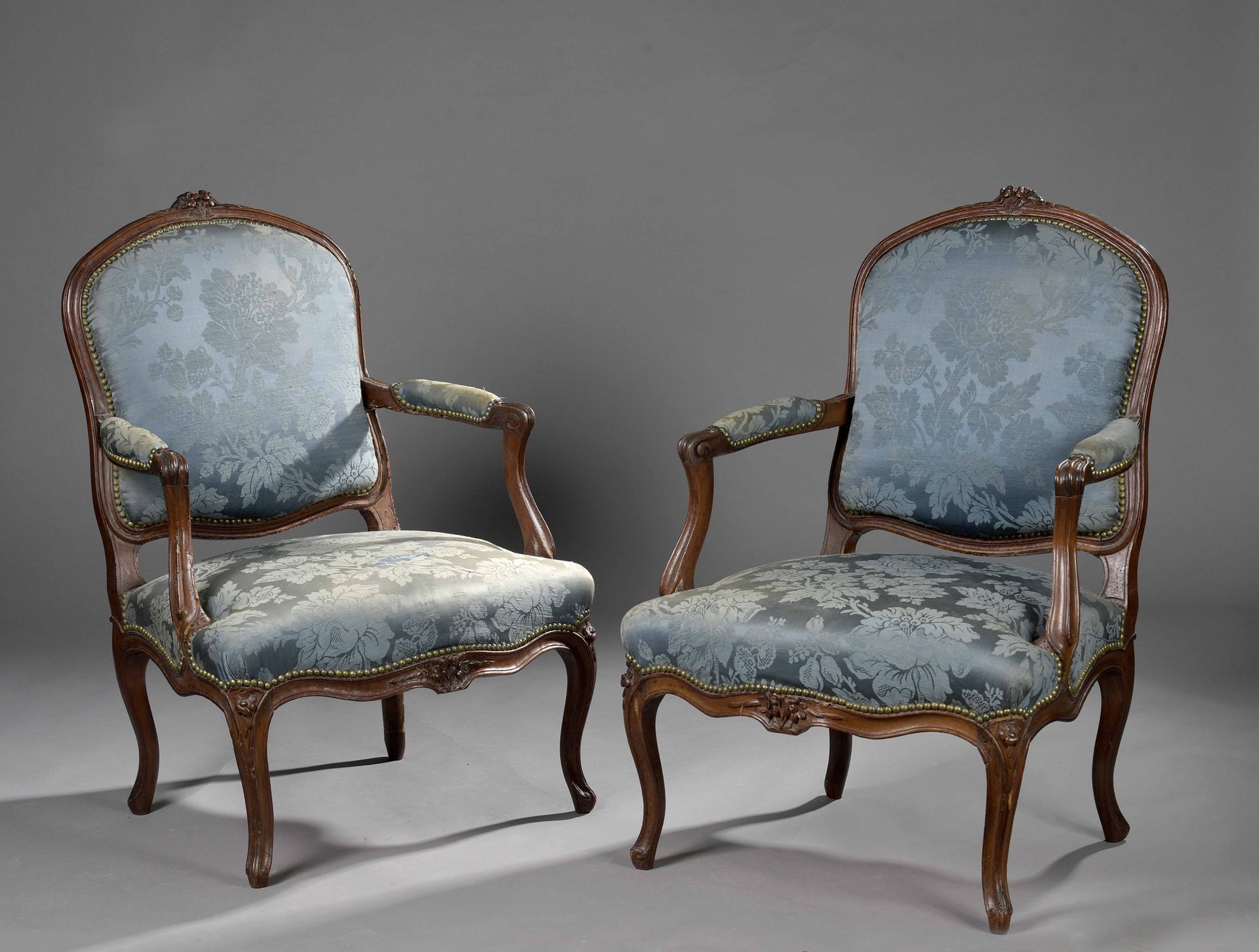 Null 一对模制和雕刻的胡桃木扶手椅，有平坦的圆形靠背，装饰着叶子和花朵。

(损坏、缺失部分和修复）。

路易十五时期。

H.94 L. 64 cm