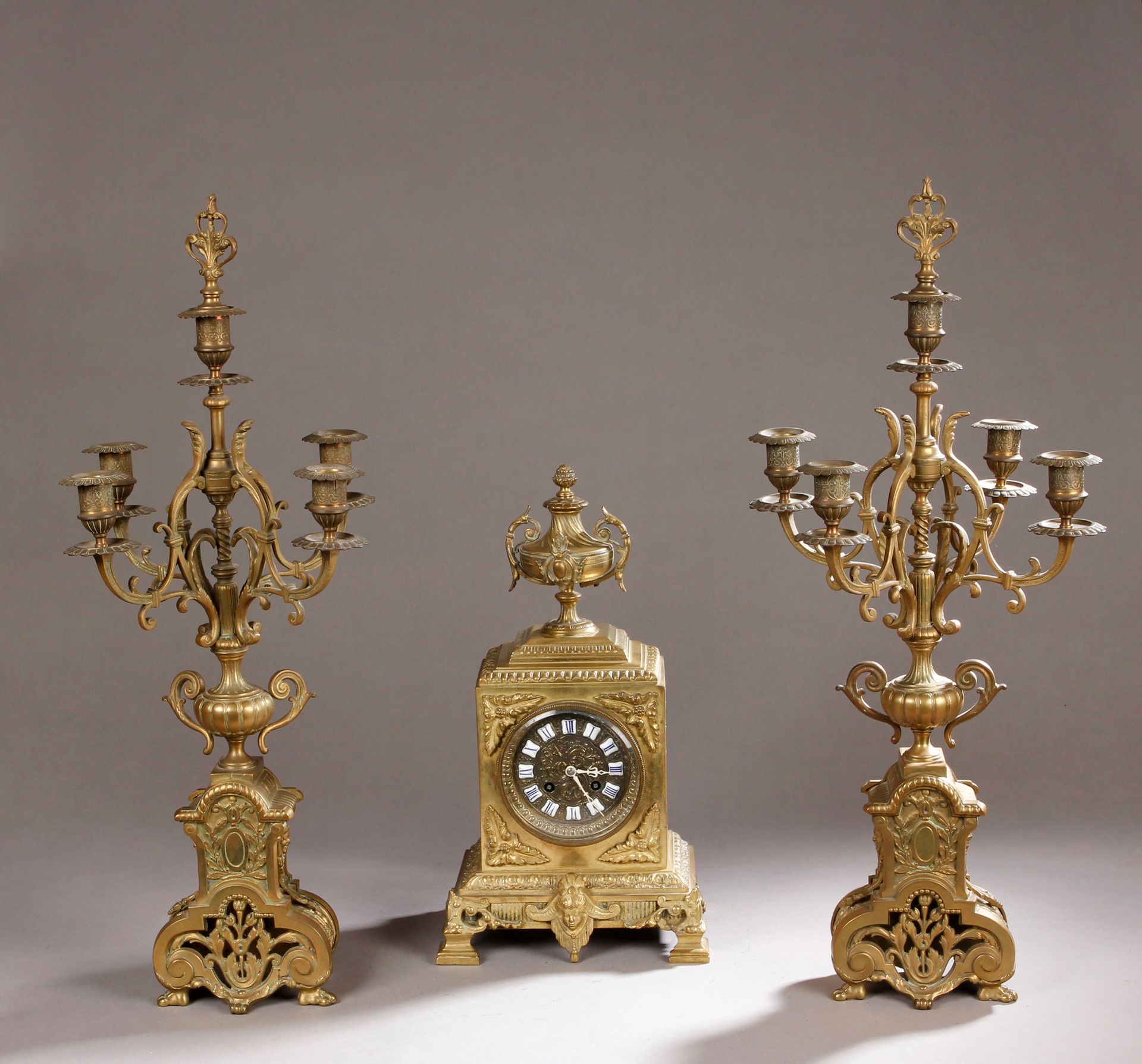 Null 带有卷轴和叶子的青铜壁炉，包括:

时钟。高：39厘米

一对5灯烛台。高：64厘米

19世纪末（不同型号）
