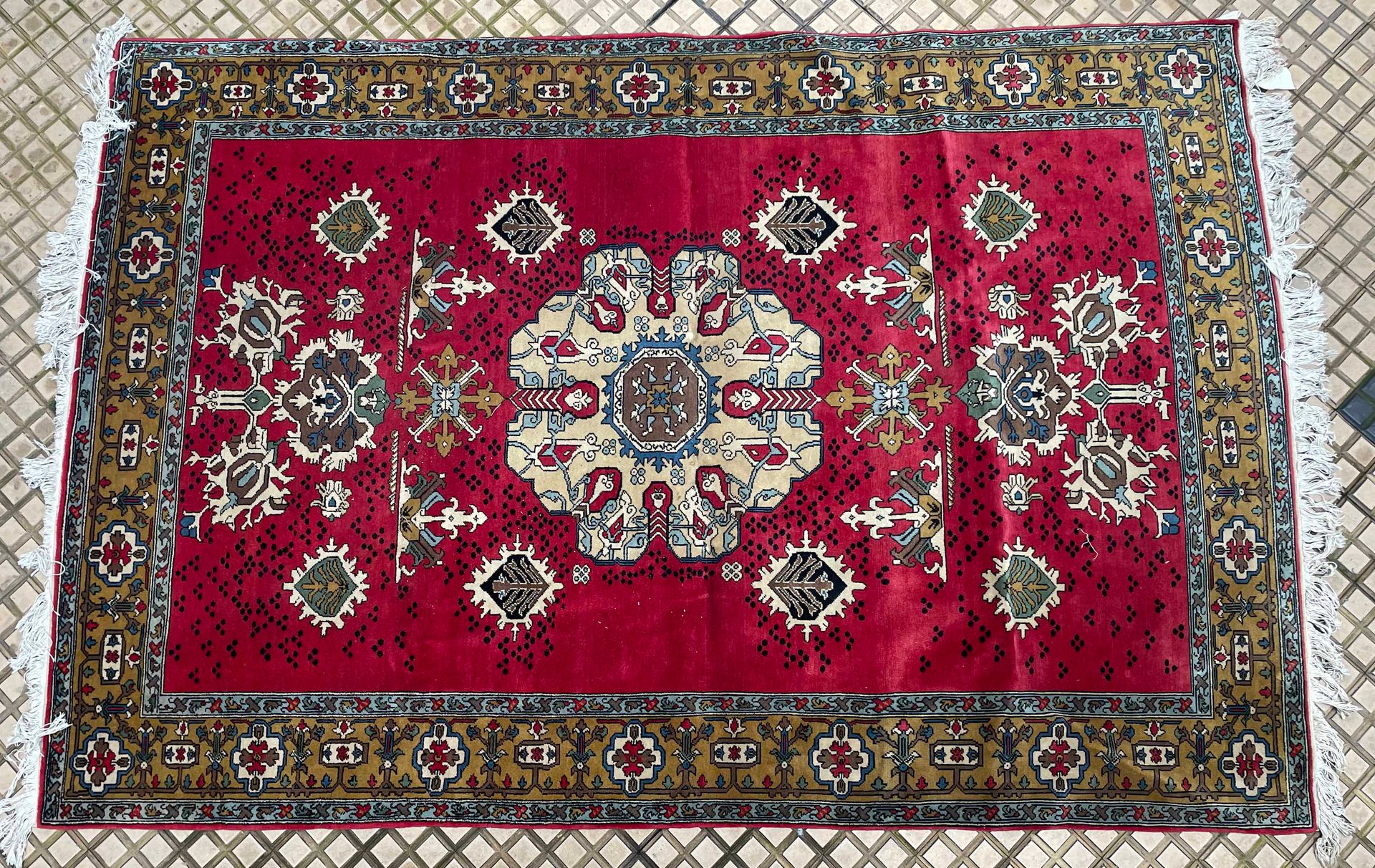 Null 地毯上有一个中央多边形徽章，在红色背景上装饰有几何图案，有三个边框，主要的边框是棕色背景。
280 x 196 cm