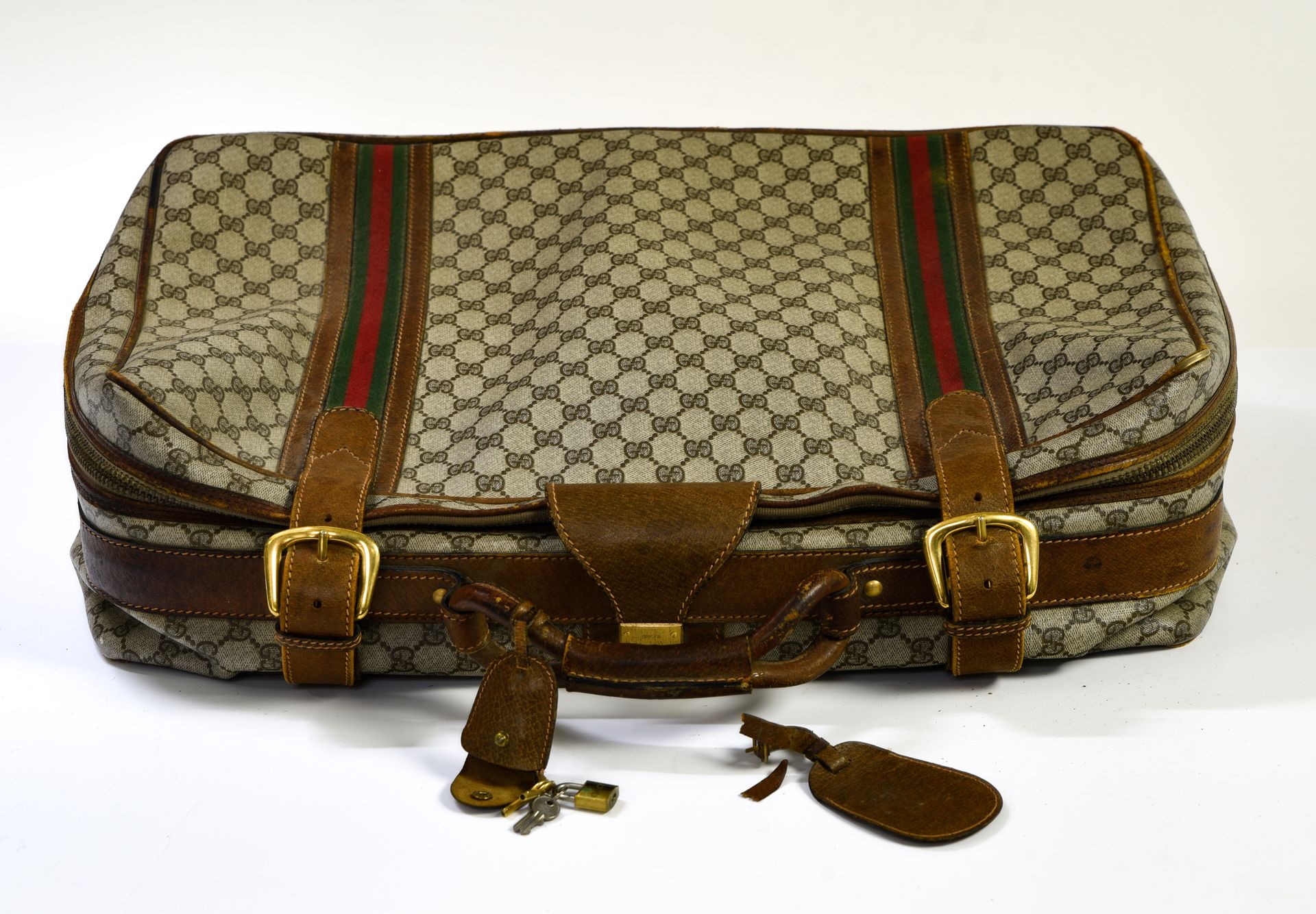 Gucci 软质旅行箱



帆布上有 "GG "字样和棕色皮革，其上有两个绿色/红色/绿色编织的棉条。箱子上都有拉链封口。

手柄两边有两个加强的扣子用于封口&hellip;