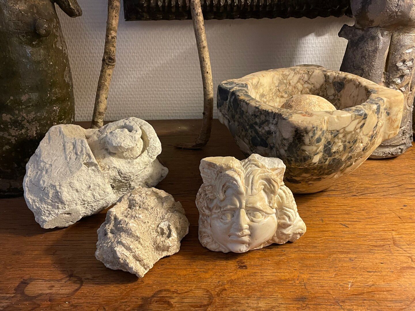 Null Marble mortar and four eroded carved stones: scroll, faces.