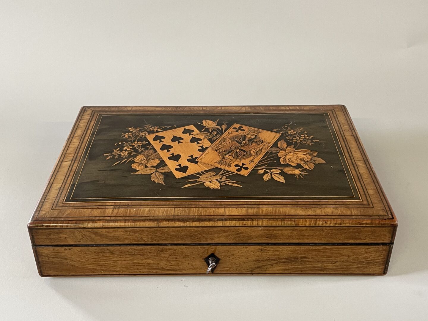 Null 游戏盒，盖子上镶嵌着扑克牌和花，内部有隔间，装有纸牌游戏和骰子。

19世纪晚期。

 7 x 31 x 21 厘米