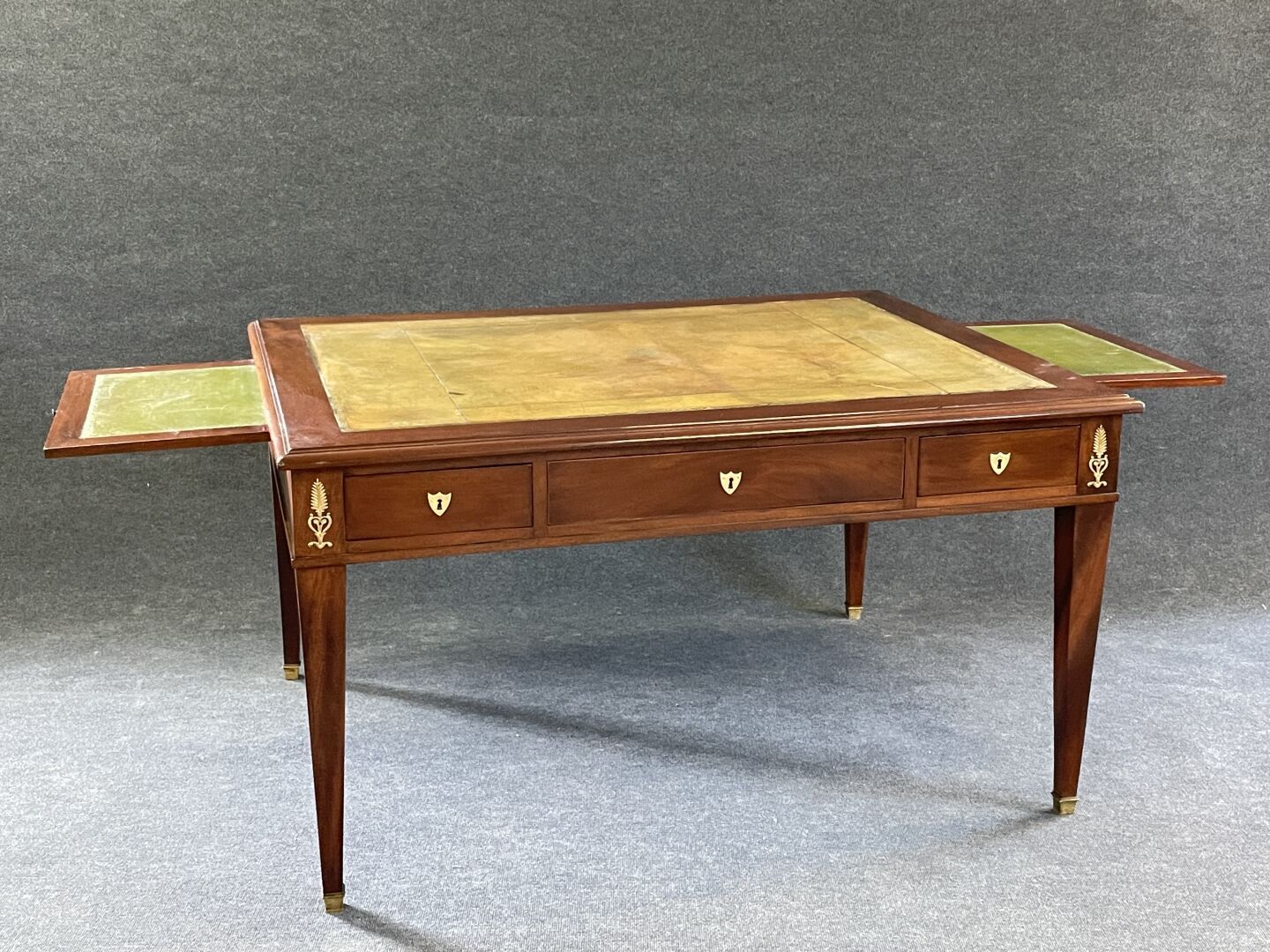 Null 桃花心木和桃花心木饰面的办公桌，双面带拉手，鞘状桌腿，皮革桌面。

路易十六风格，19世纪中期。

80 x 145 x 114厘米。