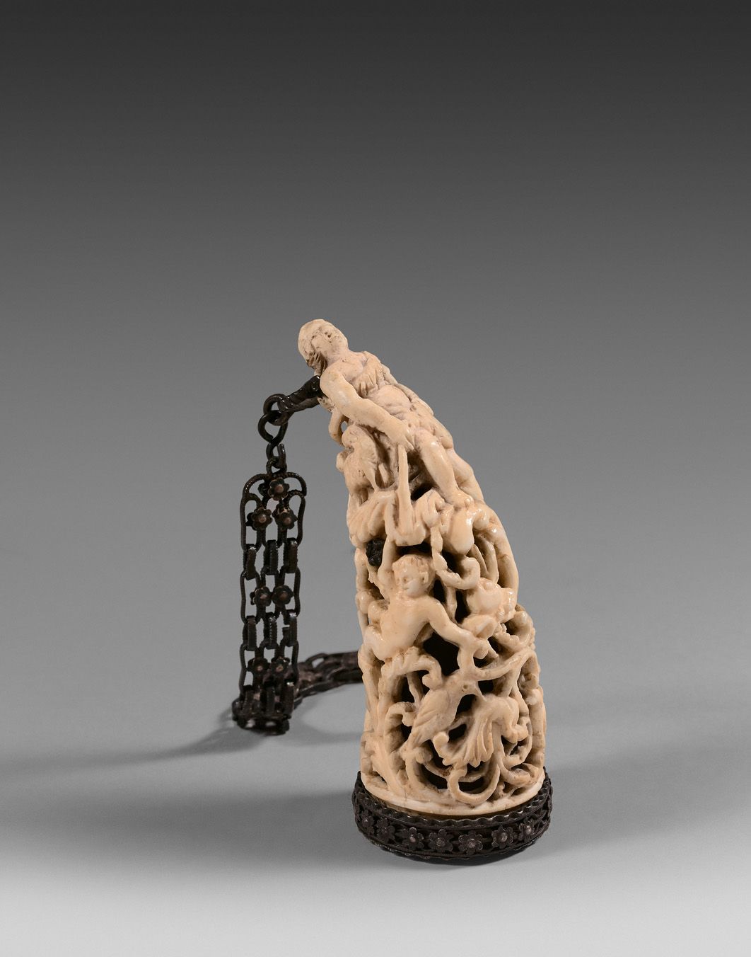 Null 一个小型的雕刻和镂空的象牙鼻烟壶，装饰有牧羊女，普蒂和鸟类的叶子。银色框架和链条。

18世纪。

高度：8厘米 - 毛重：54克。