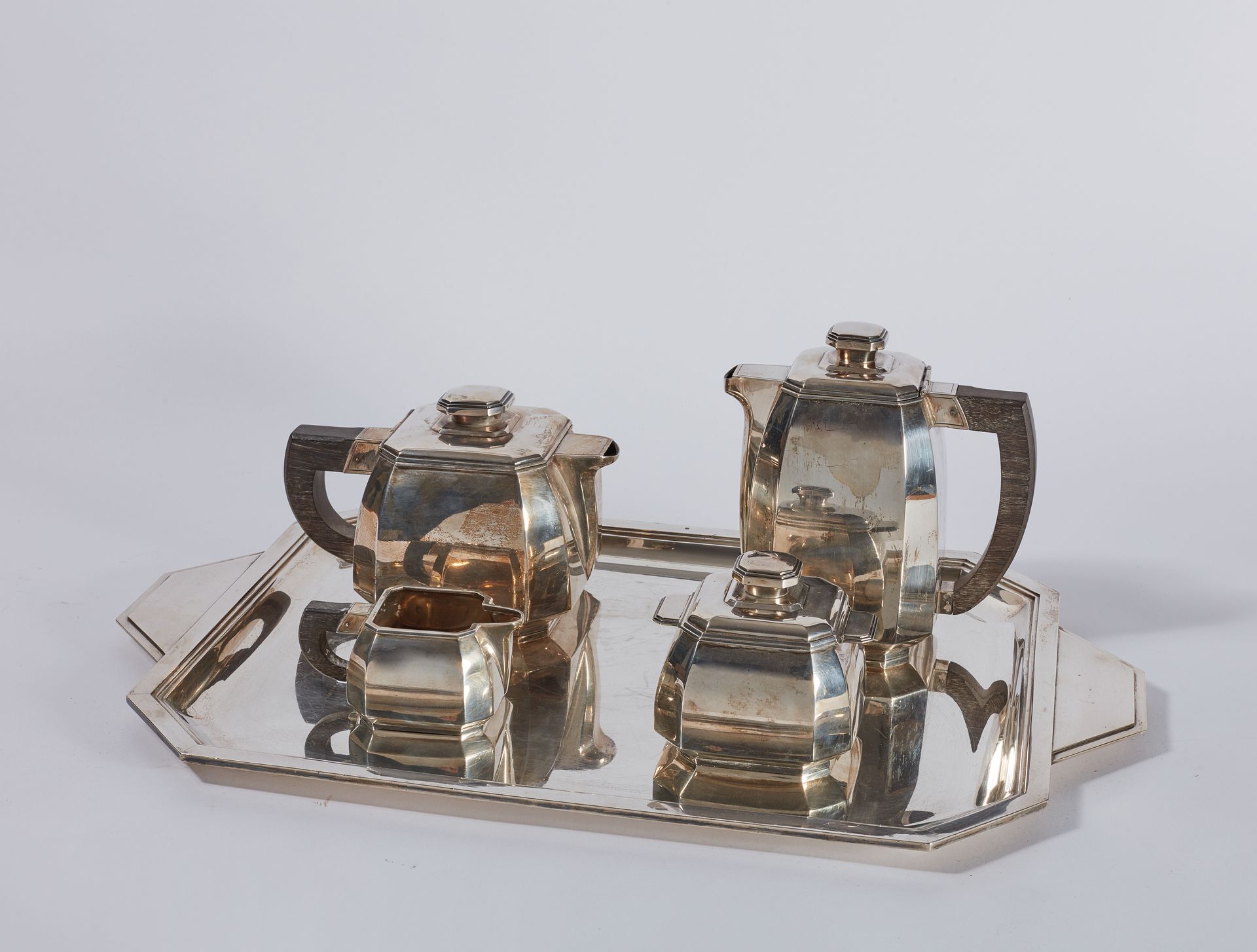 Null 一套银质茶具和咖啡具，有方形手柄和木质手柄，包括一个咖啡壶，一个茶壶，一个糖碗，一个牛奶壶和一个长方形托盘。装饰艺术风格。毛重4033克

附上：一个&hellip;