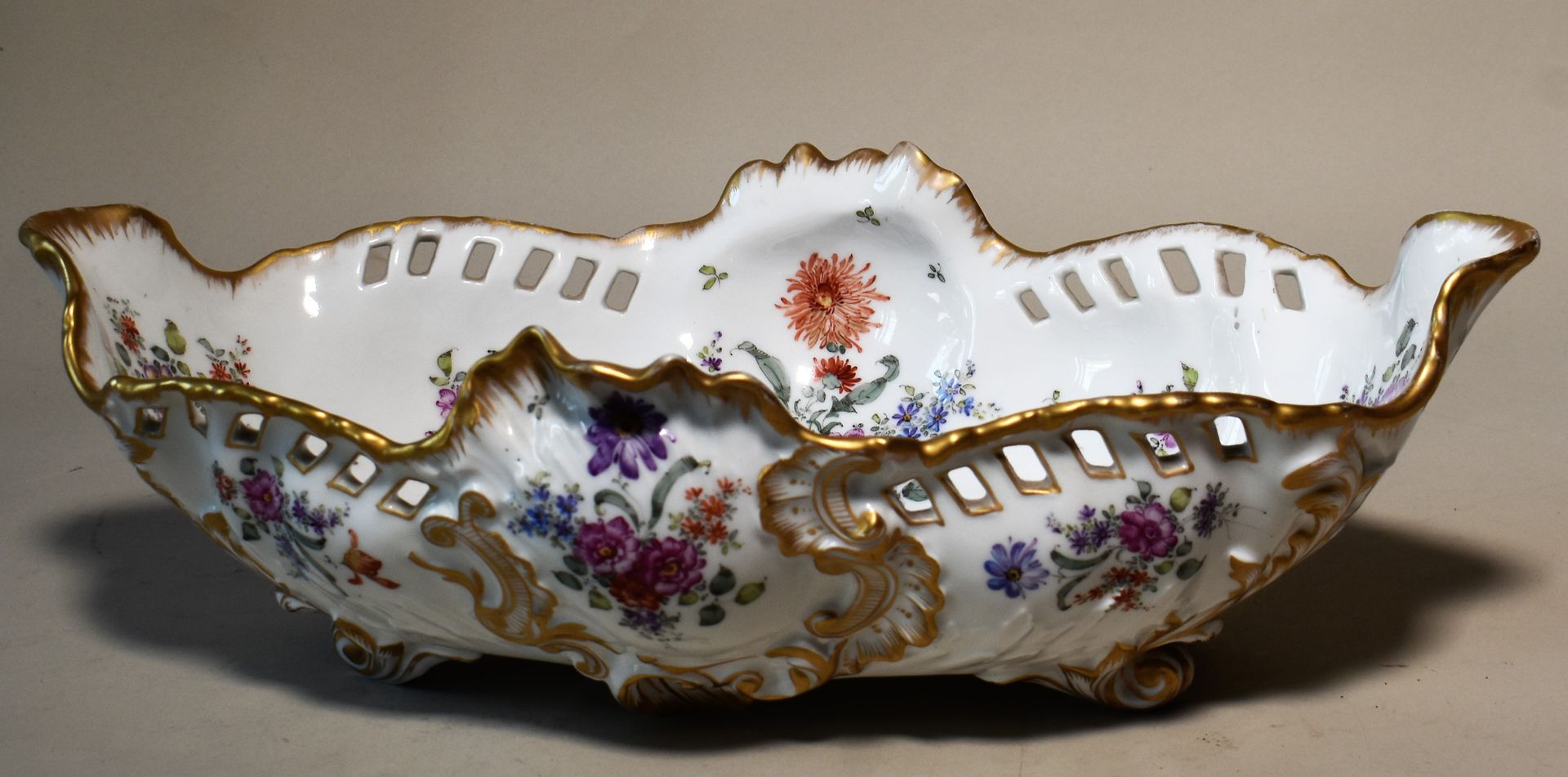 Null 饰有花束的多棱镜瓷器JARDINIERE，边缘镀金。19世纪晚期。高12 - 长43厘米

交付给书房的地段