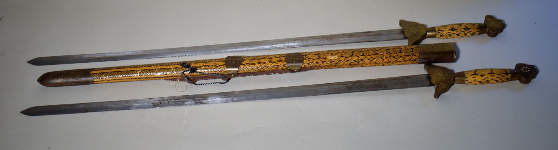 Null 雕刻的钢制双剑，剑柄和剑鞘用蛇皮包裹。长102厘米
