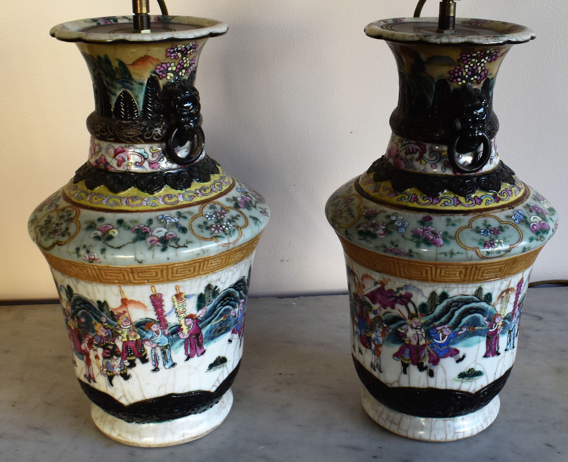 Null 中国：一对南京裂纹陶瓷花瓶，有巡游装饰和两个环形牛柄（作为灯具安装）。标记的。19世纪晚期。高度为35厘米