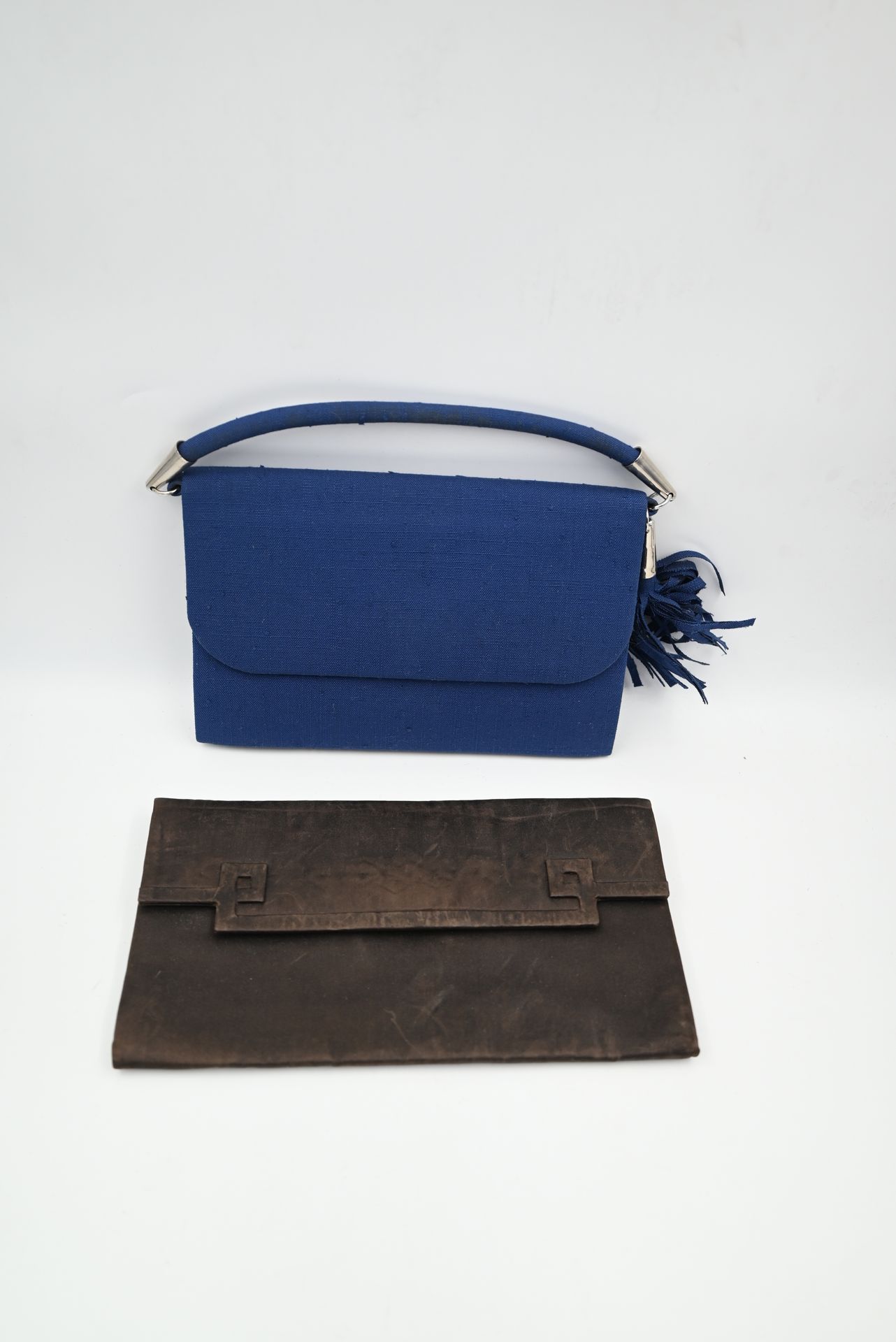 Null 克里斯蒂安-迪奥（CHRISTIAN DIOR）：带盖的棕色布袋。11.5 x 21厘米（已磨损）和带盖的皇家蓝色布手袋，银色金属饰边。12,5 x &hellip;