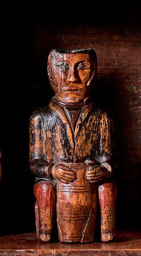 Null 雕刻的木制笔筒，显示一个坐着的人物，两腿之间夹着一个桶。

19世纪。

高17厘米

小事故。