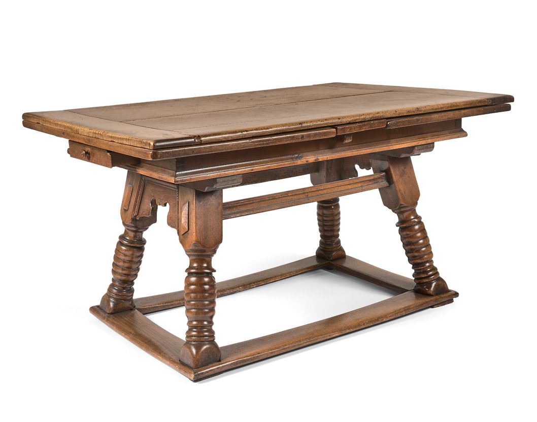 Null 瑞士胡桃木大桌，意大利风格的桌面。四个斜转和环形的立柱由边缘的一个平支架连接。末尾有两个抽屉。

18世纪。

高度75 - 宽度140/255 - &hellip;