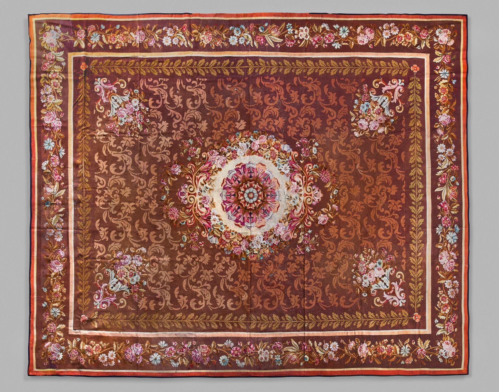 Aubusson 奥布松：棕色地毯，有叶子的装饰，中央有玫瑰花，边框有多色花。长474 - 宽386厘米
边界有小的事故和修补。
