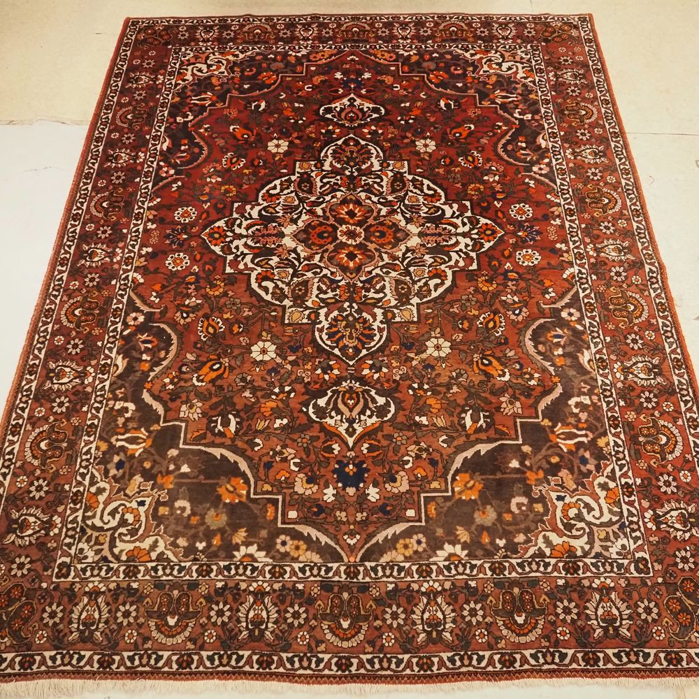 Null Bakhtiar :大约1960年，手工打结的羊毛地毯，在红色领域的浅色背景上有花纹装饰，在茄子色的背景上有4个横幅，在2个介质之间有一个非常宽的边框&hellip;