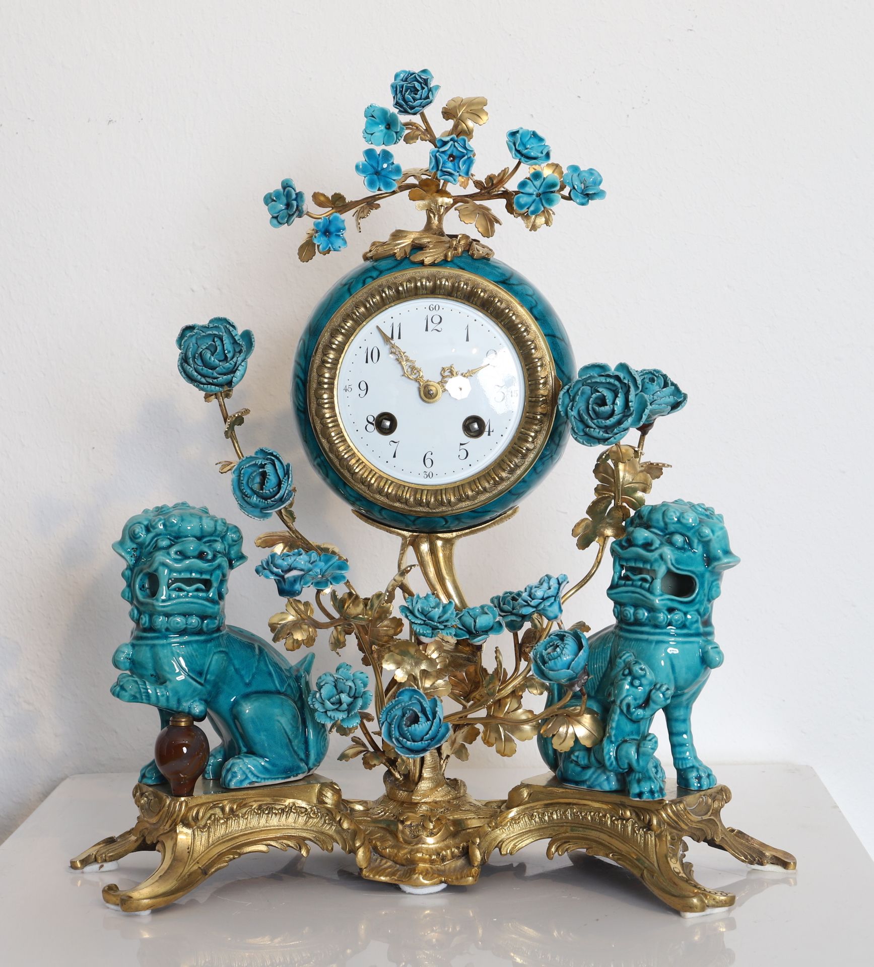Null 罕见的路易十五罗盖尔钟
镀金青铜钟身，配以绿松石釉面的中国瓷器，饰有佛狗和花卉。 
白色珐琅表盘上用阿拉伯数字显示小时。 
由于使用和维护原因进行了修&hellip;