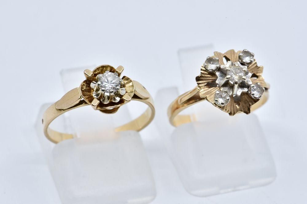 Null 
	两枚戒指，一枚镶嵌了一颗白宝石，另一枚镶嵌了五颗白宝石的风格化花朵图案。

鹰标志。

18K黄金，750/°°

毛重：4.93g。

T.D.&hellip;