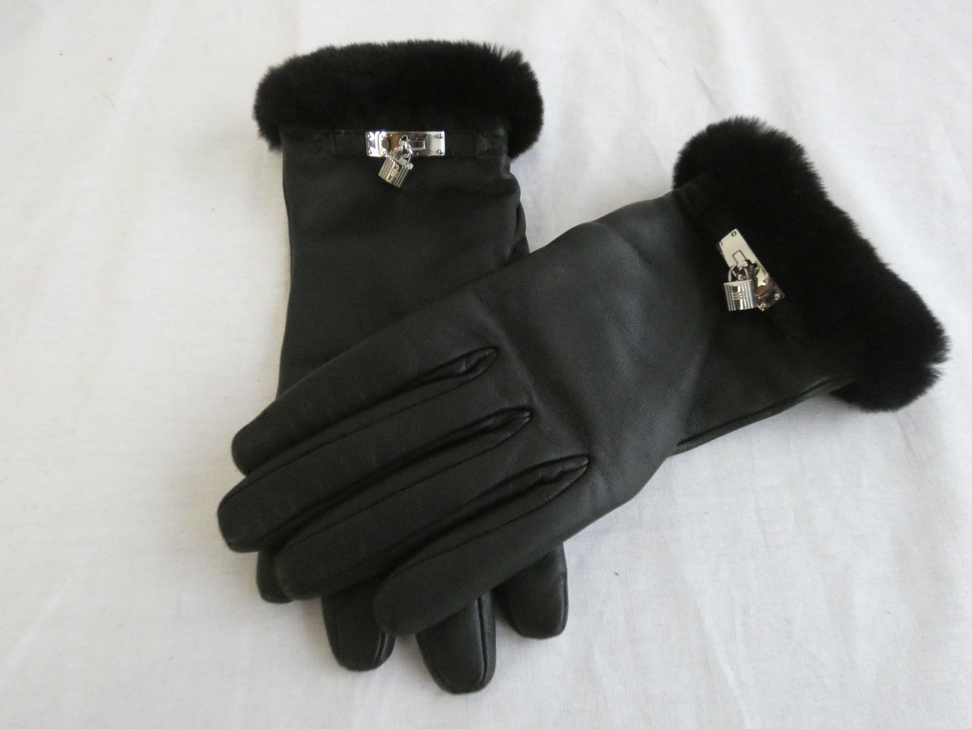Null 
	法国制造的HERMES巴黎

一对黑色小羊皮手套，镶有水貂刨花的颜色，"Kelly "袖扣为镀银钯金，内衬为米色羊绒。T.7.5.状况极佳。
存放&hellip;