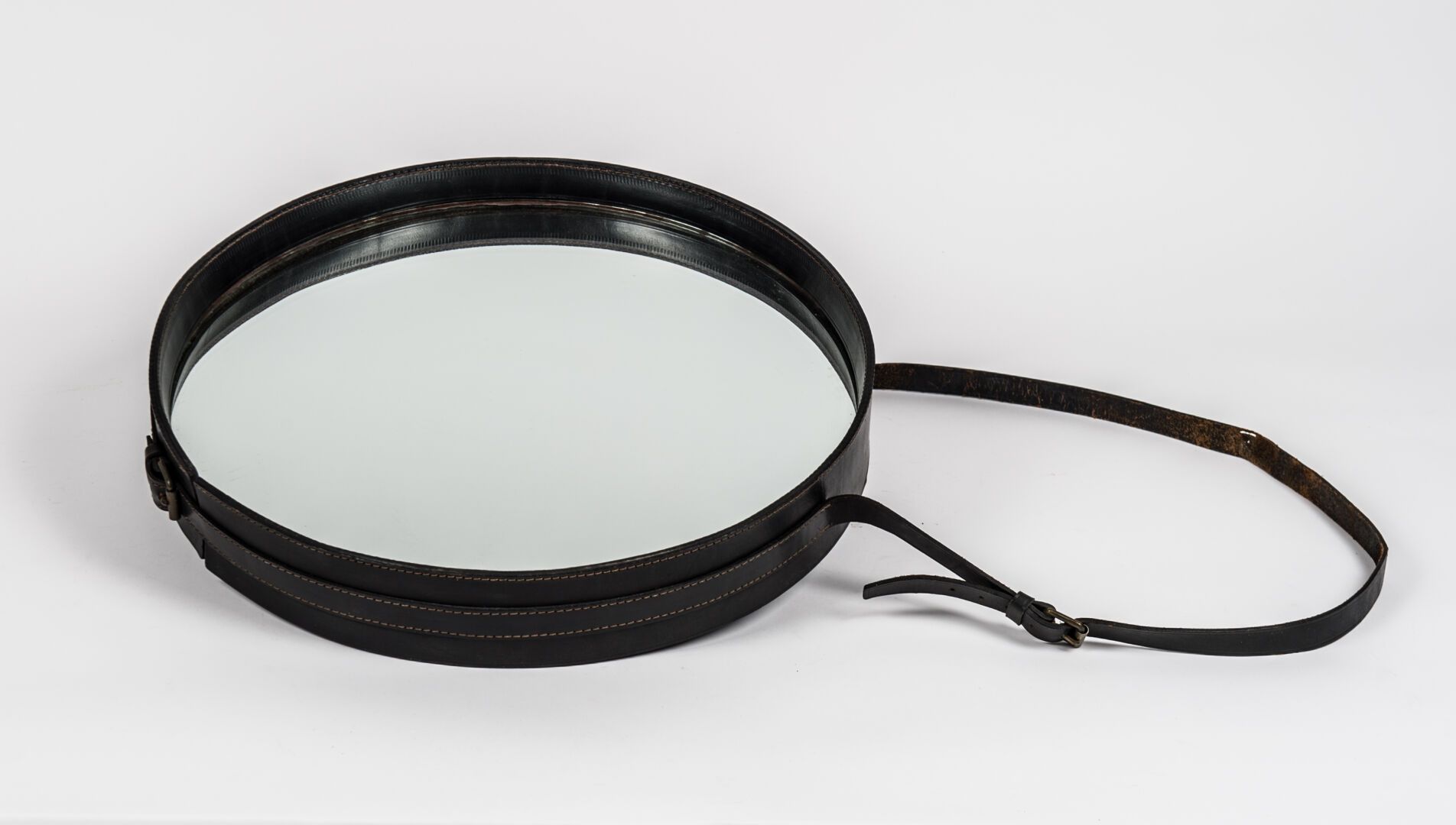 Null 
雅克-阿德内（1900 - 1984）。黑色马鞍线缝制的圆形镜子，及其高度可调的连接带（直径：45.5厘米）（轻微磨损，特别是悬挂带，边缘有非常小的&hellip;